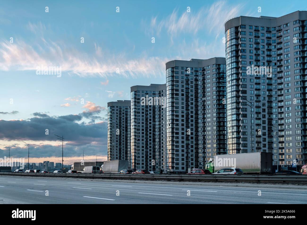 Moderne Skyline der Stadt. Abends dynamischer Verkehr auf einer Straße. Geschäfts-, Wirtschafts- und Finanzkonzept. Platz für Text kopieren. Stockfoto