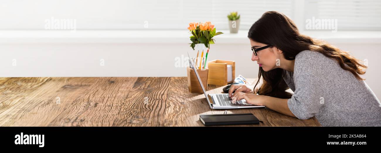 Frau Mit Schlechter Körperhaltung, Die Bei Der Arbeit An Der Rezeption Sitzt Stockfoto