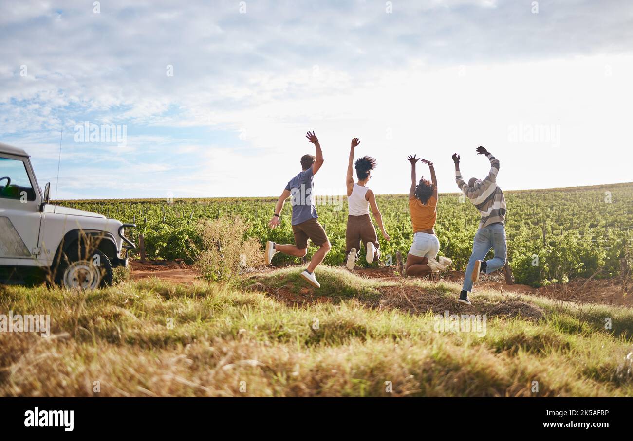 Springen, Freiheit und Freunde in einem Feld in der Natur, während auf einem Sommer Road Trip Urlaub auf dem Land. Gruppe, Reisen und glückliche Menschen mit Energie auf Stockfoto