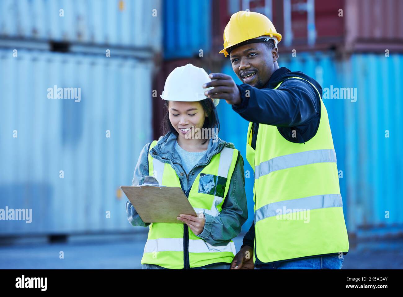 Fracht-, Schifffahrt- und Logistikmitarbeiter mit Checkliste für den internationalen und globalen Frachttransport in einem Hafen. Teamarbeit, Zusammenarbeit und Bereitstellung Stockfoto