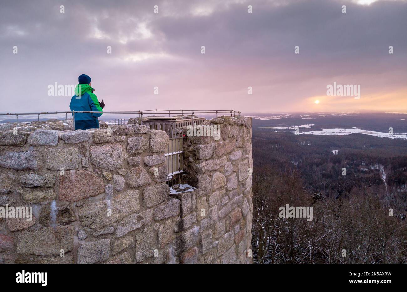 Ein Mann, der den malerischen Sonnenuntergang von der Ruinenburg Weissenstein in Regen, Deutschland, genießt Stockfoto