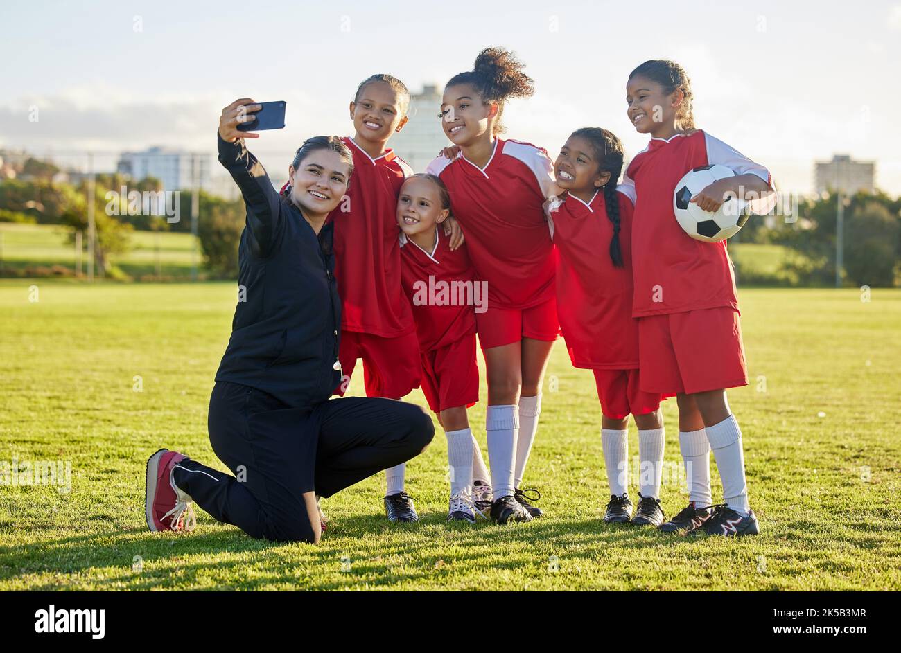 Fußballplatz, Mädchenmannschaft und Coach Selfie für Social Media nach Training, Wettkampf und Spiel gemeinsam im Freien. Glückliche Kinder, lächeln Lehrer und Stockfoto