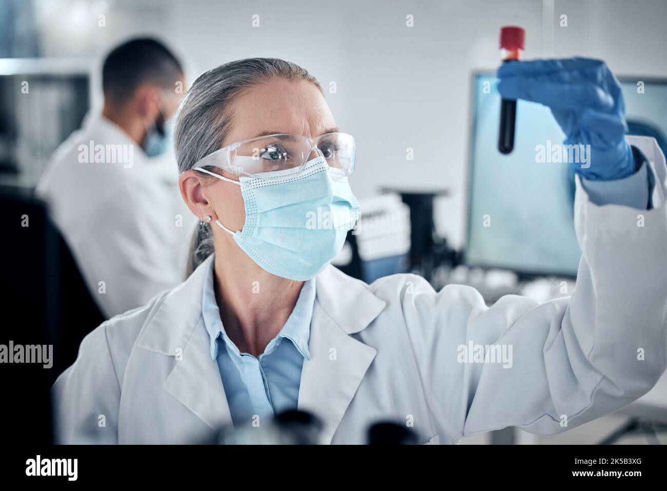 Bluttest, Laborforschung und Wissenschaftler, die an der Entwicklung der Gesundheitswissenschaften mit Gesichtsmaske arbeiten, um Sicherheit zu gewährleisten. Reifer Arzt, der Analyse auf Stockfoto