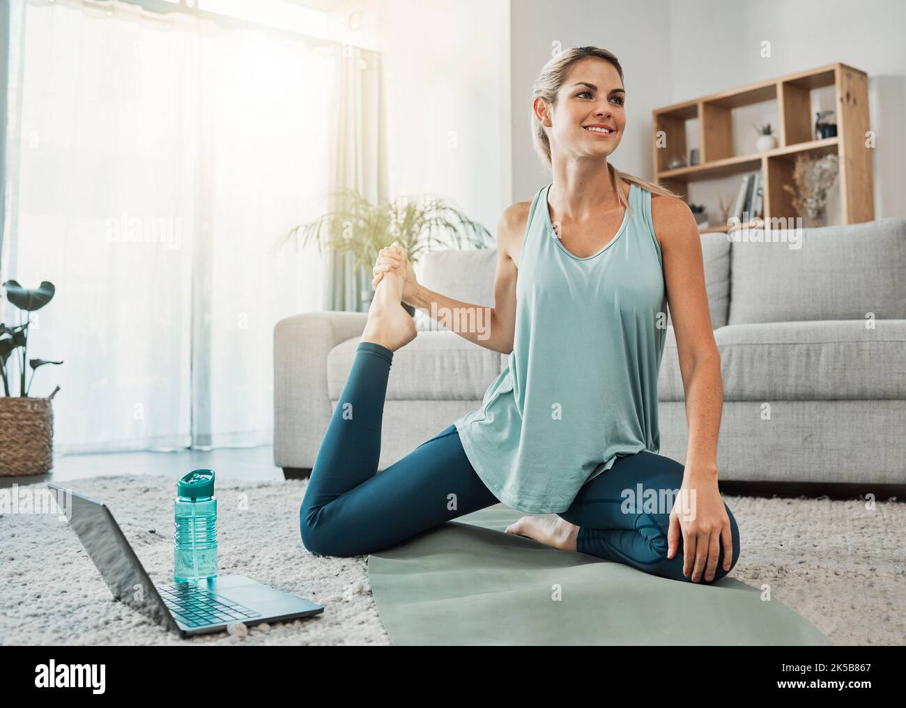 Stretching Legs und Yoga-Webinar auf einem Laptop für den Lifestyle im Online-Workout für Frauen zu Hause. Fitness-Mädchen genießen Muskeltraining im Internet Stockfoto