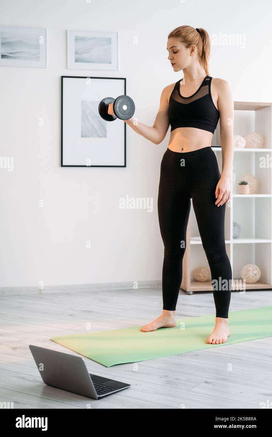 Online-Fitness-Training zu Hause Frau mit Hantel Stockfoto