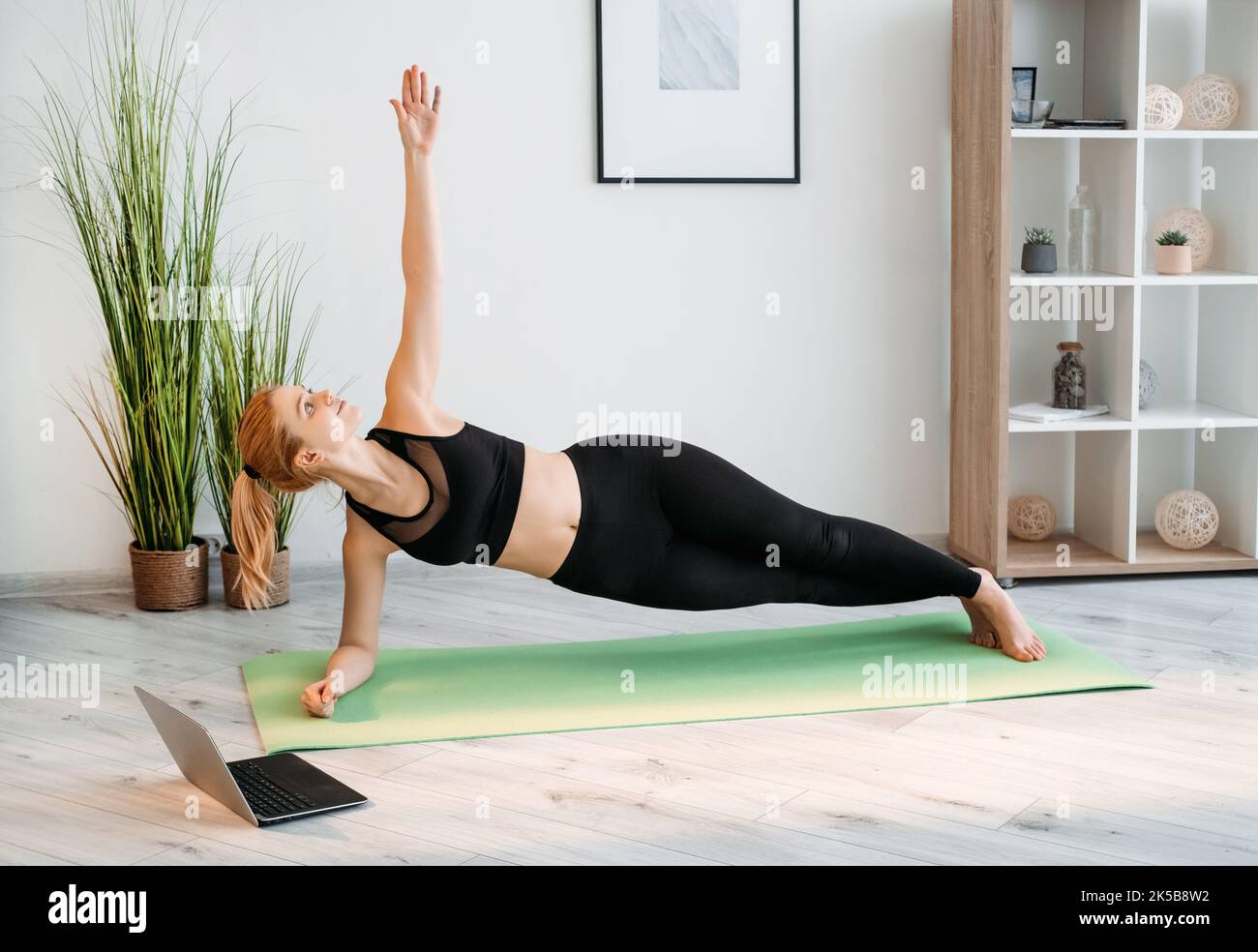Online-Fitness-Training zu Hause Übung Frau Laptop Stockfoto
