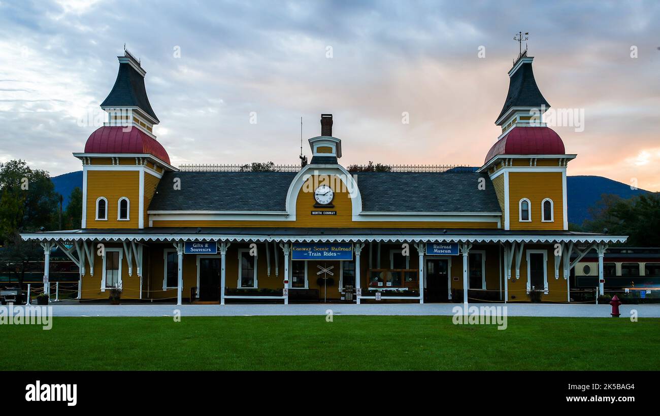 NORTH CONWAY, NEW HAMPSHIRE, USA - 1. OKTOBER 2022: Conway Scenic Railroad Bahnhofsgebäude mit Abendhimmel und Sonnenuntergang Stockfoto