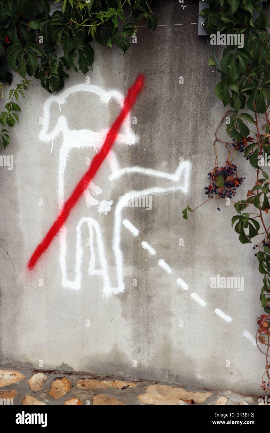 Graffiti eines Hundes, der mit einer Linie durch ihn uriniert Stockfoto