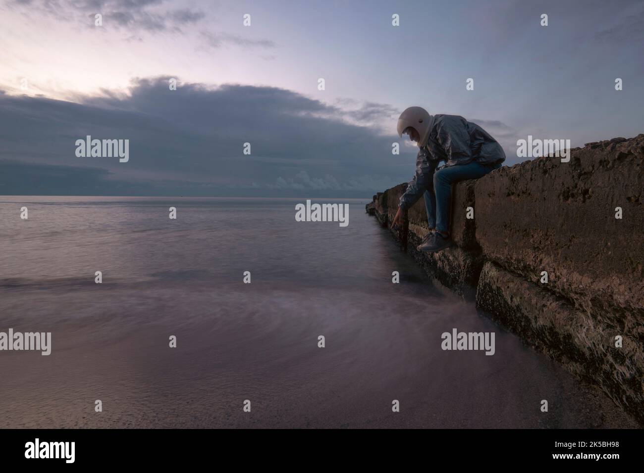 Astronaut mit 3D bedrucktem Helm, der auf eine Qualle zeigt. Konzept: Allein außerirdische Welten erkunden Stockfoto