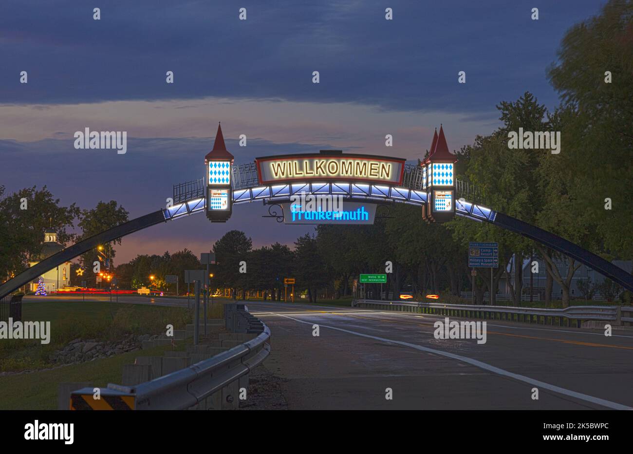 Das Frankenmuth-Begrüßungsschild auf der anderen Seite der Straße beleuchtet nachts Willkommen nach Frankenmuth Michigan USA in Michigan's Little Bavaria Stockfoto