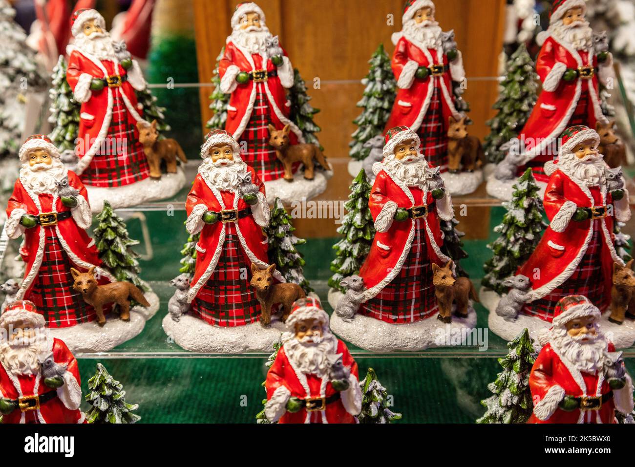 Weihnachtsschmuck mehrerer Weihnachtsmann-Figuren auf Einem Regal in Einem Geschäft zum Verkauf zur Weihnachtszeit. Weihnachtsmann, St. Nicholas, St. Nick, Stockfoto