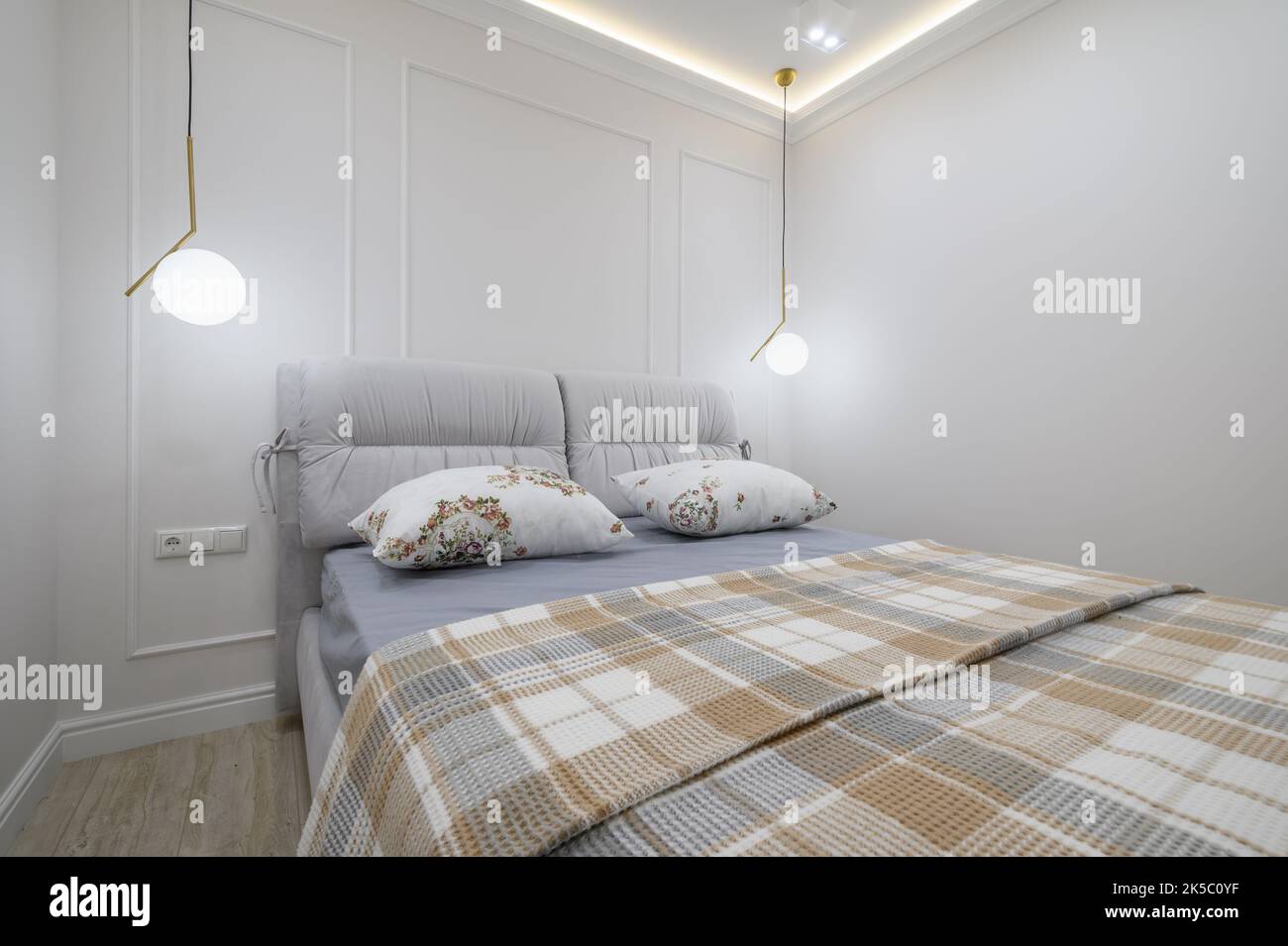 Stilvolles Interieur aus grauem und weißem Schlafzimmer mit komfortablem Bett Stockfoto