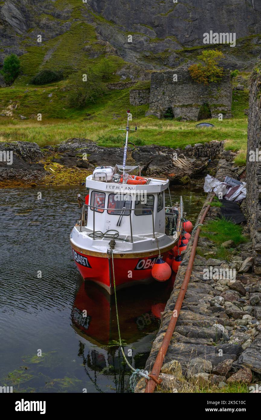 Fischerboot vor Sailien Harbour mit den alten Kalköfen dahinter, Isle of Lismore, Schottland Stockfoto