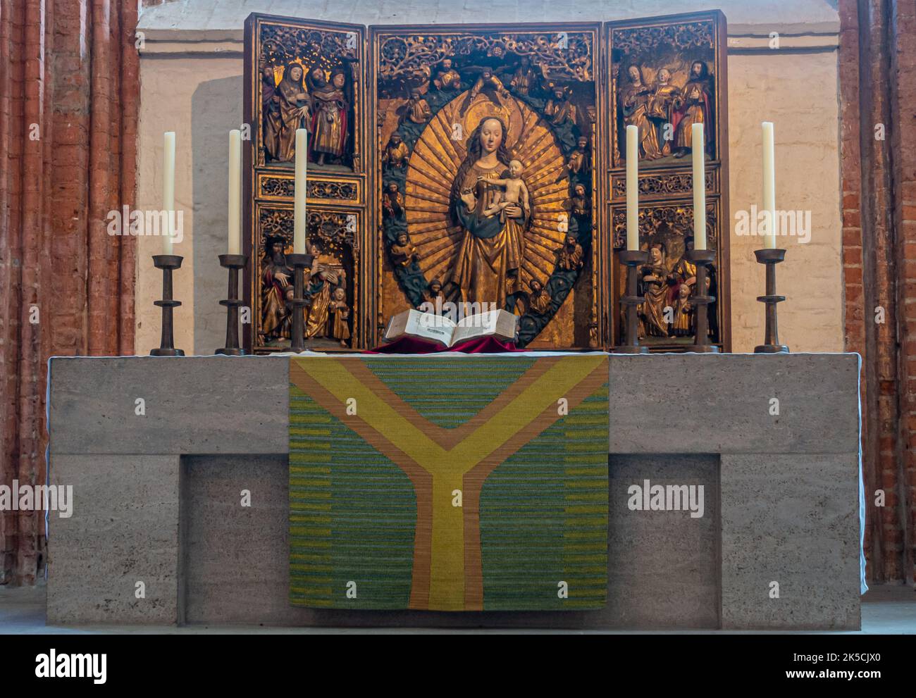 Deutschland, Lübeck - 13. Juli 2022: Marienkirche. Madonna oder Marienaltar mit 3-dimensionalen bunten und historischen Reredos hinter dem Festtisch. Stockfoto