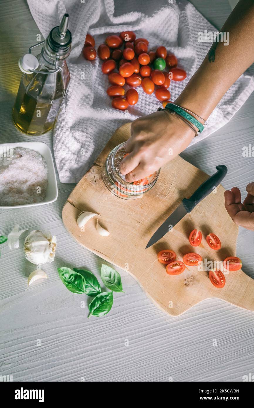 Hausgemachte Zubereitung, Tomaten in Öl mit Knoblauch, Basilikum Stockfoto