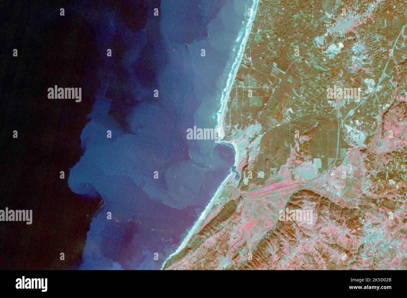 Nazare, Portugal, ist ein Küstenort, der für seine hohen Winterwellen von über 30 Metern bekannt ist. Das Gebiet ist bei Surfern beliebt und weist sichtbare Sedimentmuster auf, die auf Offshore-Strömungen hinweisen. Das Bild umfasst 18 x 25,7 km bei einem Breitengrad von 39,6°N und einem Längengrad von 9,1°W, aufgenommen am 24. November 2009. Stockfoto