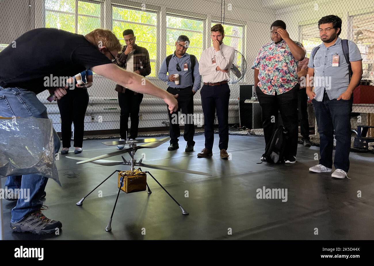 Die Teilnehmer der NASA-Minderheitseinrichtungen, die dem Space Accelerator-Programm dienen, umgeben ein vollständiges Modell des Mars Ingenuity-Hubschraubers der NASA, während der Ingenieur Michael Starch die Mission diskutiert. Die Gruppe besuchte am 18. August 2022 das Jet Propulsion Laboratory der NASA. Diese Teilnehmer waren Mitglieder von drei Teams, die als Preisträger im ersten Beschleunigerprogramm ihrer Art benannt wurden, einem Wettbewerb, der die Ziele der NASA vorantreiben und ihre Bedürfnisse in den Bereichen maschinelles Lernen, künstliche Intelligenz und Entwicklung autonomer Systeme erfüllen soll, während gleichzeitig unterrepräsentierte akademische Institutionen und r engagiert werden Stockfoto
