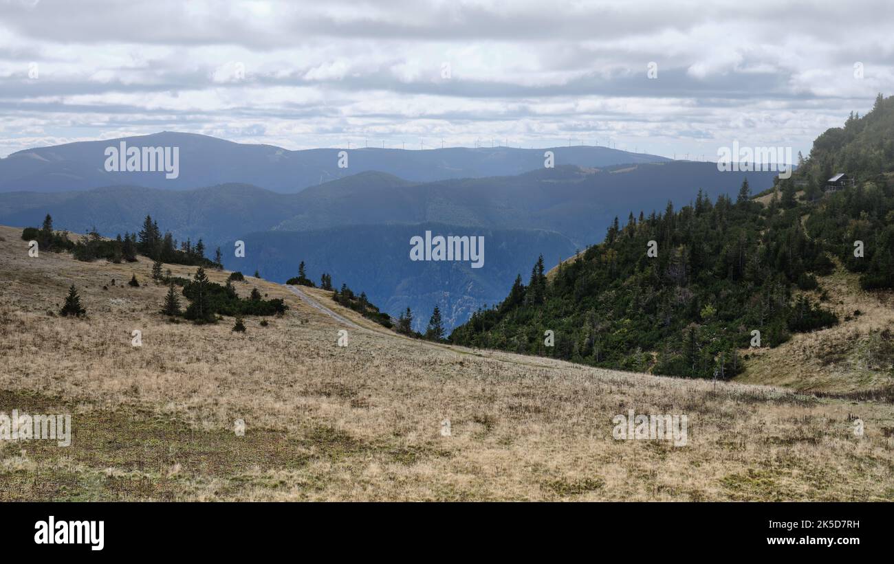 Panoramablick auf sanfte Hügel und bewaldete Berglandschaft vom Rax-Gebirge in Österreich, mit geschichteten fernen Gipfeln, alpiner Landschaft und Stockfoto