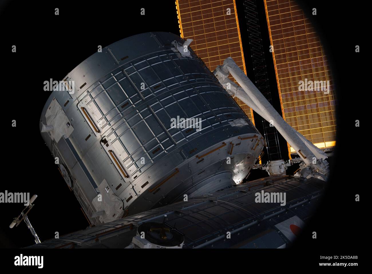 Vom CST-100 Starliner-Fenster aus ist das Kibo-Labormodul der ISS von JAXA zusammen mit einem Teil des Roboterarms und der wichtigsten Solararrays sichtbar. Stockfoto