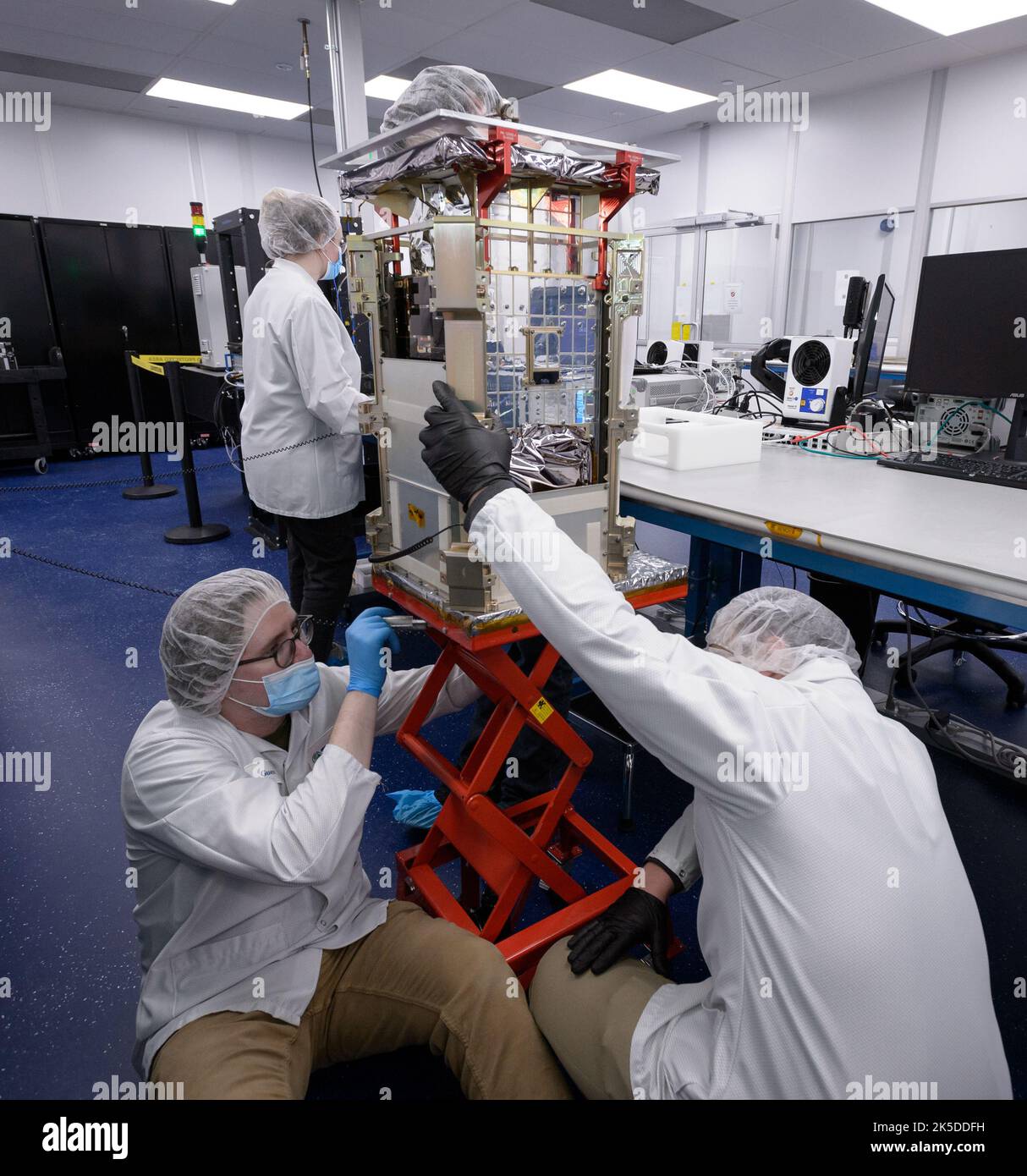 Matt Johnson, CAPSTONE Lead Systems Engineer, Bottom, Dustin Holta, Launch Engineer, Right, Und Rebecca Rogers, Systemingenieurin, Hintergrund, mit der CAPSTONE-Sonde, die in ihrem Spender bei Tyvak Nano-Satellite Systems, Inc., in Irvine, Kalifornien, verstaut wurde. Stockfoto Matt Johnson, CAPSTONE Lead Systems Engineer, Bottom, Dustin Holta, Launch Engineer, Right, Und Rebecca Rogers, Systemingenieurin, Hintergrund, mit der CAPSTONE-Sonde, die in ihrem Spender bei Tyvak Nano-Satellite Systems, Inc., in Irvine, Kalifornien, verstaut wurde. Stockfoto