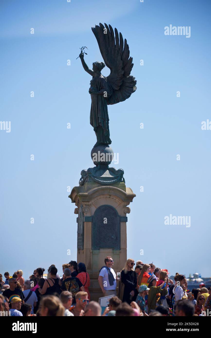 Brighton & Hove Pride Festival, Brighton & Hove, East Sussex, England. Die Friedensstatue an der Grenze zwischen Brighton und Hove, umgeben von einer Menschenmenge. Stockfoto