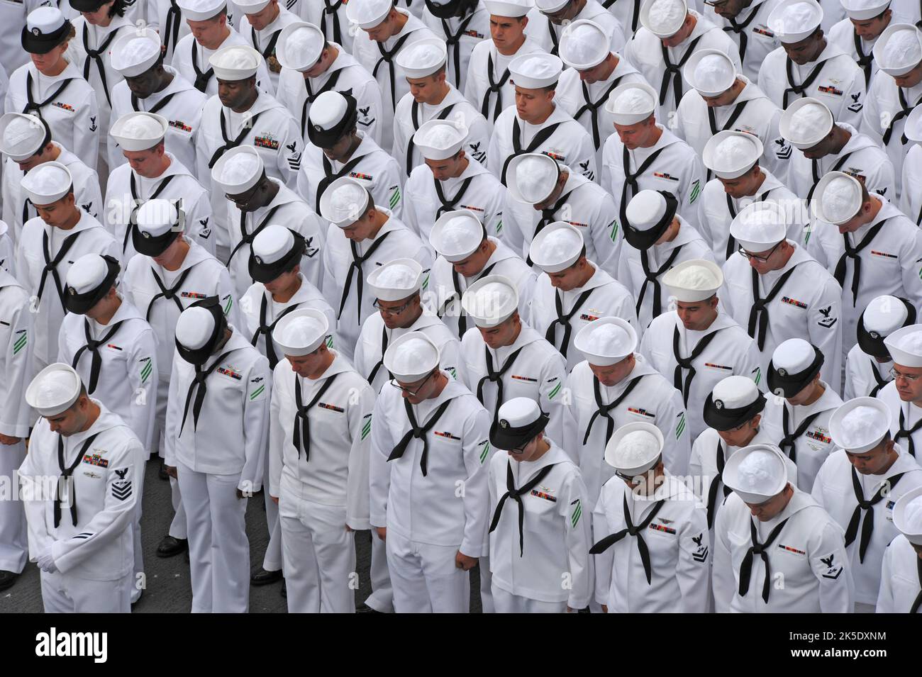 US-Seeleute, die dem amphibischen Angriffsschiff USS Makin Island (LHD 8) zugewiesen wurden, beugen sich während einer Zeremonie zur Befehlsänderung auf dem Flugdeck des Schiffes am 14. Juni vor. Während der Zeremonie wurde Capt. Cedric E. Pringle von Capt. Alvin Holsey entlastet. SAN DIEGO, 14. Juni 2013 optimierte Version eines US Navy-Foto. Kredit US Navy/M.E.Wagoner Stockfoto