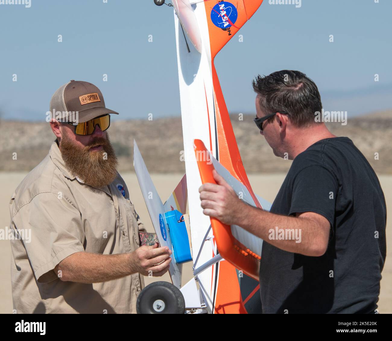 Justin Hall, links, bringt das vorläufige aerodynamische Design der Forschung an Land on Mars, oder Prandtl-M, an den Carbon-Z Cub an, den Justin Link steadies. Hall and Link sind Teil eines Teams vom Armstrong Flight Research Center der NASA in Edwards, Kalifornien, das einen experimentellen Magnetfreisetzungsmechanismus verwendet, um den Schirm zu starten. Stockfoto