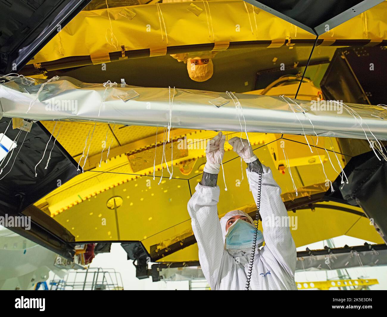 Vorbereitung des James Webb Space Telescope (JWST). Installation von Flug-Wärmedecken auf der Struktur, die den Sekundärspiegel des JWST in einem Reinraum in Northrop Grumman, Redondo Beach, Kalifornien, USA, unterstützt. Schnüren, die Decken an den Streben befestigen. Da die Decken gebunden (und auch genäht) sind, gehören die Mitglieder dieses Teams zu den einzigartigsten, die über Hintergründe verfügen, die Schneiderei und Kostümherstellung umfasst haben, bevor sie in der Luft- und Raumfahrtindustrie arbeiten. Eine optimierte Version eines NASA-Bildes vom erfahrenen Hauptfotografen Chris Gunn. Quelle: NASA/Chris Gunn. Nur für redaktionelle Zwecke Stockfoto