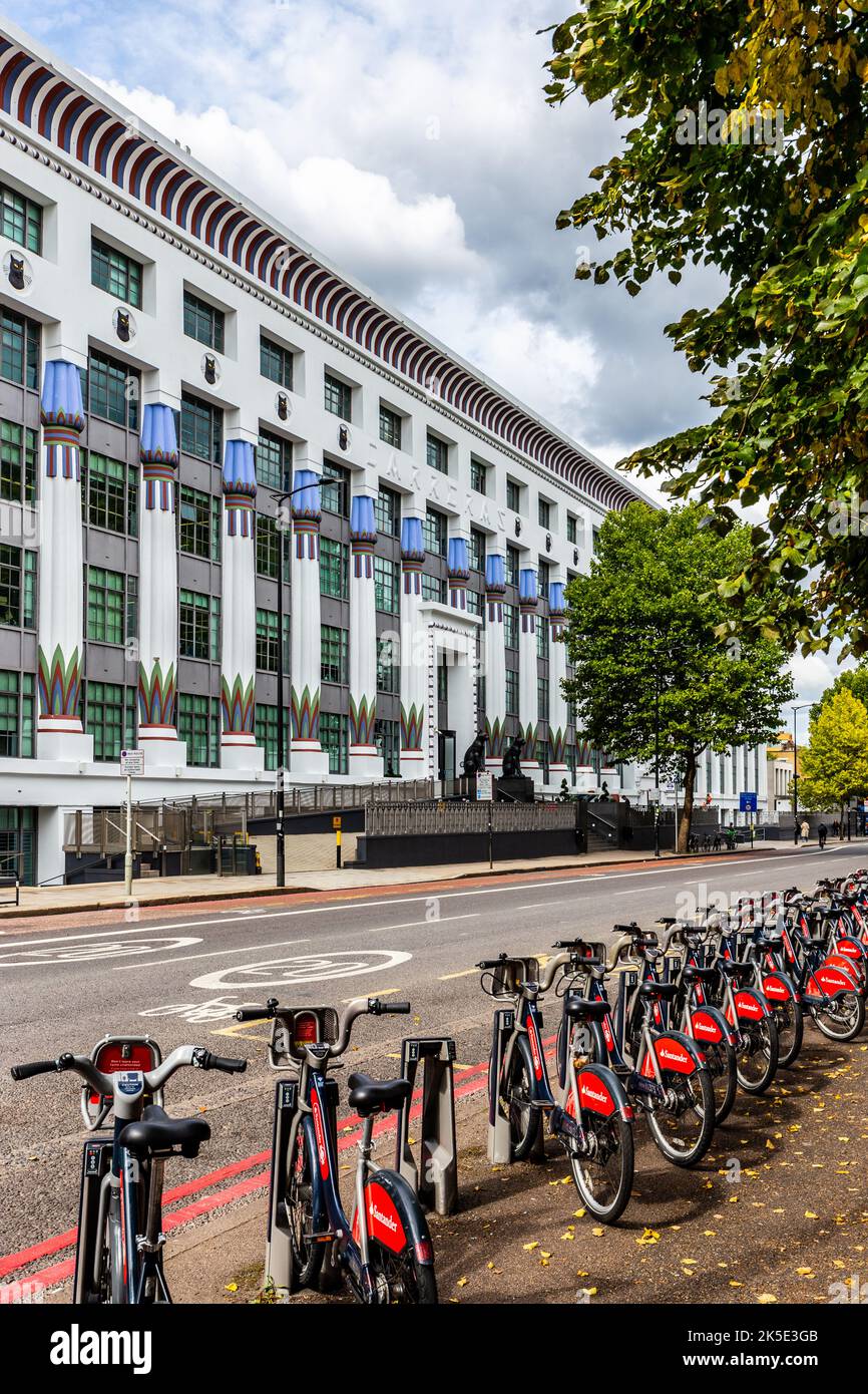 Eine Reihe von Santander mietet Fahrräder, die gegenüber dem berühmten Carreras Art déco-Gebäude in Camden warten.das Gebäude beherbergt heute Hunderte von Büromitarbeitern. Stockfoto