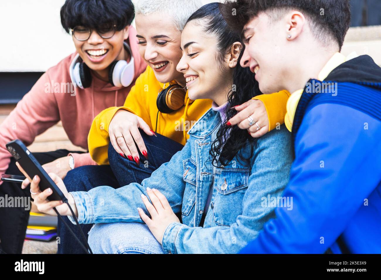 Freunde von Studenten verschiedener Rassen, die Spaß daran haben, Social-Media-Inhalte in der App zu sehen Stockfoto