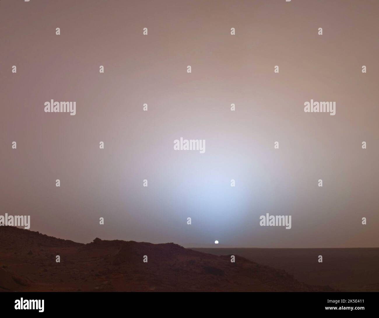 Am 19.. Mai 2005 hat der Mars Exploration Rover Spirit der NASA diese atemberaubende Aussicht eingefangen, als die Sonne unter den Rand des Gusev-Krater auf dem Mars sank. Dieses Mosaik der Panoramakamera wurde um 6:07 am Abend des Mars-Tages des Rover 489., kurz sol, aufgenommen. Andere Bilder haben gezeigt, dass der Schein der Dämmerung bis zu zwei Stunden vor Sonnenaufgang oder nach Sonnenuntergang sichtbar, aber zunehmend schwächer bleibt. Die lange Dämmerung des Mars (im Vergleich zur der Erde) wird durch Sonnenlicht verursacht, das auf die Nachtseite des Planeten durch reichlich Höhenstaub gestreut wird. Eine optimierte Version der NASA-Bilder. Kredit NASA/JPL Stockfoto