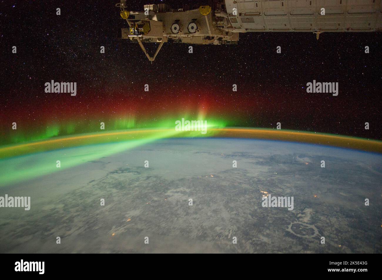 Fotografiert von der Internationalen Raumstation am 3. Februar 2012. Die grünen Schleier und Vorhänge der aurora borealis, die sich über Quebec, Kanada, erstrecken. Unten rechts ein Eiskreis auf dem gefrorenen Reservoir, das jetzt den Einschlagskrater Manicouagan (70km quer) einnimmt. Lichter der Stadt offenbaren kleine Siedlungen. Die aurora borealis (Nordlichter) ist das Licht, das leuchtet, wenn geladene Teilchen aus der Magnetosphäre durch Sonnenstürme beschleunigt werden. Der schwächere Lichtbogen, der sich parallel zum Horizont befindet, wird als Airglow bezeichnet. Eine optimierte Version eines Originalbildes der NASA. Quelle: NASA Stockfoto