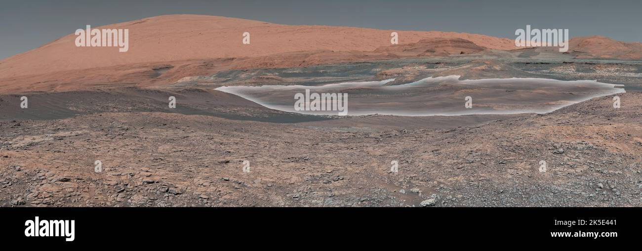 Marsoberfläche, Mars. Dieses Mosaik des Mars Cursority Rover der NASA blickt bergauf den Mount Sharp, den Cursory seit 2014 bestiegen hat. Weiß hervorgehoben ist ein Gebiet mit tonhaltigen Gesteinen, das Wissenschaftler gerne erkunden möchten; es könnte zusätzliche Licht auf die Rolle des Wassers bei der Schaffung von Mount Sharp werfen. Das Mosaik wurde aus Dutzenden von Bildern zusammengestellt, die von Curioys Mast Camera (Mastcam) aufgenommen wurden. Es wurde im Januar 2018 auf Sol 1931 aufgenommen. Eine optimierte Version eines NASA-Bildes. Quelle: NASA/JPL-Caltech/MSSS Stockfoto