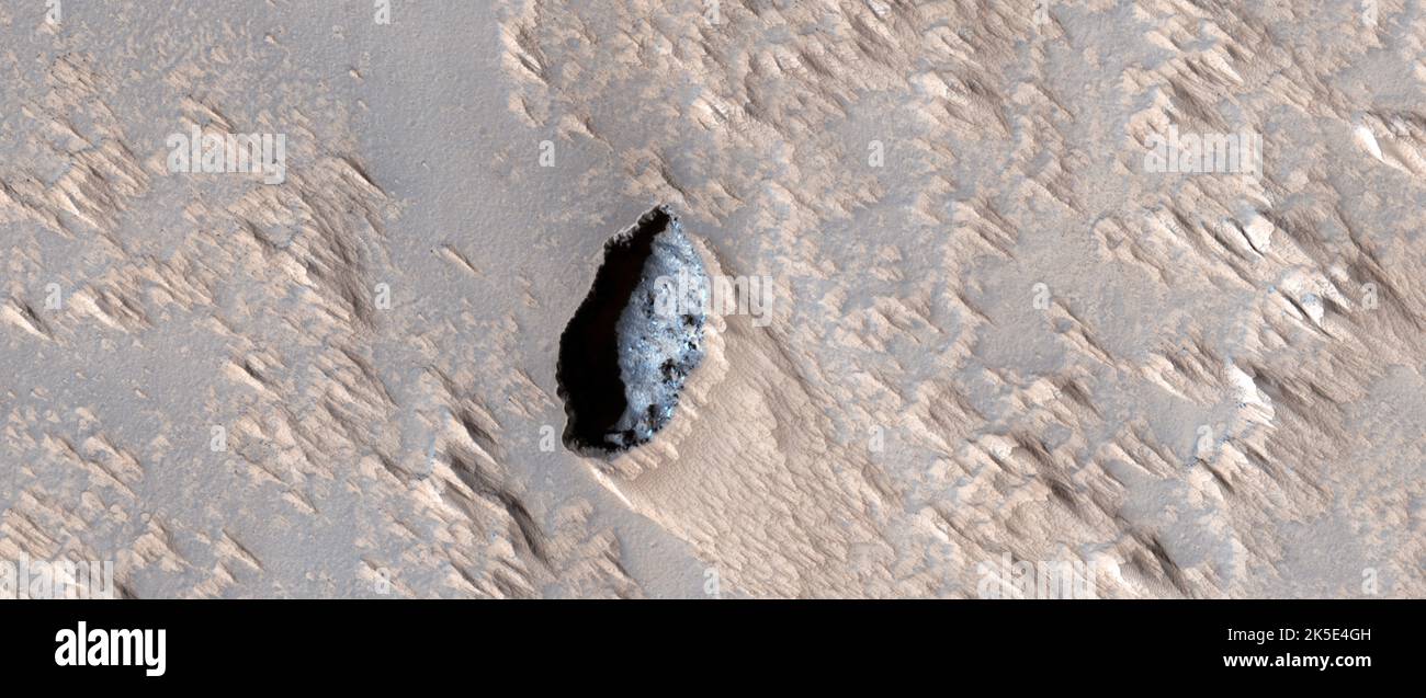 Marsatlandschaft. Dieses HiRISE-Bild eine Grube auf Arsia MonsWir haben dieses Bild aufgenommen, um festzustellen, ob eine darunter liegende Lücke (z. B. ein offener Bruch) und damit verbundene Fehler beobachtet werden können. Gruben können geologisch jüngste tektonische oder vulkanische Aktivitäten widerspiegeln. Alle damit verbundenen Höhlen könnten Ziele für zukünftige Roboterexplorationen sein. Das Bild ist weniger als 5 km (3 mi) und liegt 251 km (156 mi) über der Oberfläche. Eine einzigartige optimierte Version von NASA-Bildern. Quelle: NASA/JPL/UArizona Stockfoto