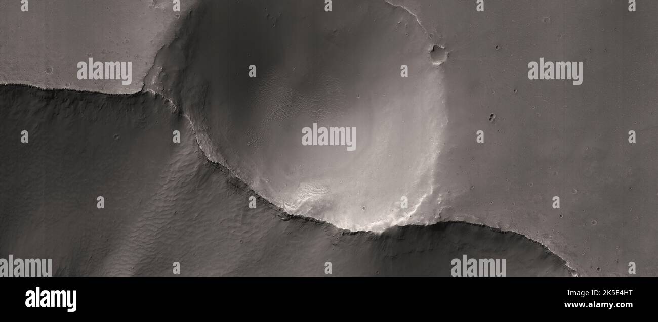 Marsatlandschaft. Dieses HiRISE-Bild zeigt Landformen auf der Oberfläche des Mars. Hier wurde ein kleiner Krater durch Erosion halbiert und im Querschnitt freigelegt. Diese Arten von „Schnittkratern“ bieten eine einzigartige Möglichkeit, die unterirdische Geometrie von Einschlägen zu betrachten und auch Erosions- und Erdrutschprozesse zu bewerten. Eine einzigartige optimierte Version von NASA-Bildern. Quelle: NASA/JPL/UArizona Stockfoto