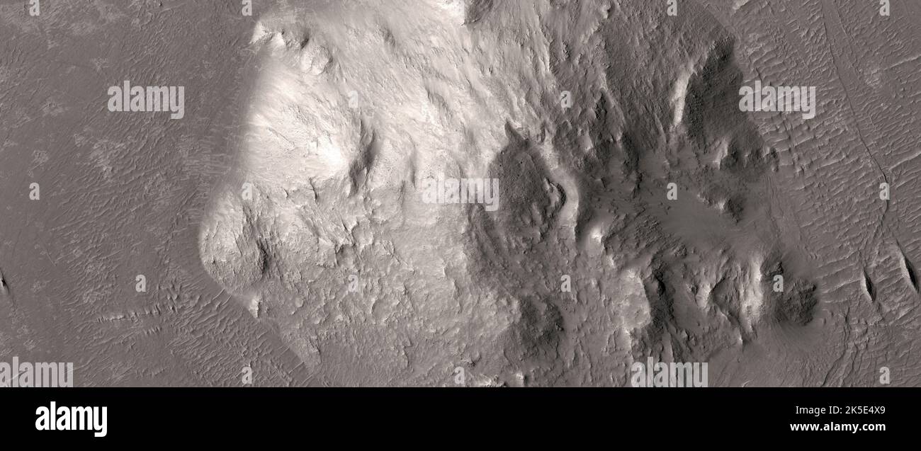 Marsatlandschaft. Dieses HiRISE-Bild zeigt einen zentralen Gipfel, der von einem ringartigen graben und relativ flachem Gelände umgeben ist. Zeigt der graben Beweise für das, was Geologen als „differentielle Verdichtung“ bezeichnen? Verdichtung bezieht sich auf Sediment, das ursprünglich porös ist und von anderem Sediment (genannt "Belastung") bedeckt ist, das diese Porosität reduziert. Eine differenzielle Verdichtung ist, wenn es Abweichungen in der Dicke eines bestimmten Bereichs gibt, die eine unebene Oberfläche erzeugen und unterschiedliche Porosität Aufweisen, Eine einzigartige optimierte Version der NASA-Bilder. Quelle: NASA/JPL/UArizona Stockfoto