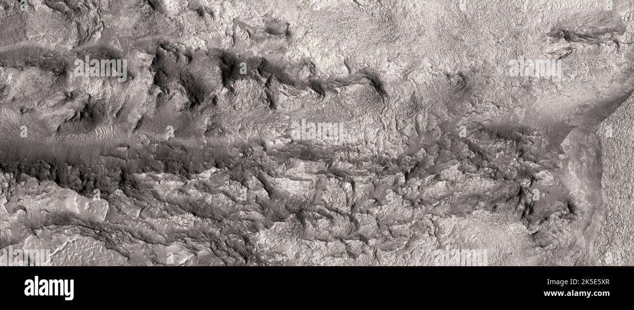Marsatlandschaft. Dieses HiRISE-Bild zeigt geschichteten Grundgestein nordwestlich der Hellas-Region, dem Mars.Dieses Bild kann helfen, ein Mosaik des Gebiets zu vervollständigen, da andere benachbarte Bilder auch aufschlussreiche Aufnahmen des Grundgesteins zeigen.Dieses Bild ist weniger als 5 km (3 mi) weit entfernt und liegt 255 km (158 mi) über der Oberfläche. Eine einzigartige optimierte Version von NASA-Bildern. Quelle: NASA/JPL/UArizona Stockfoto