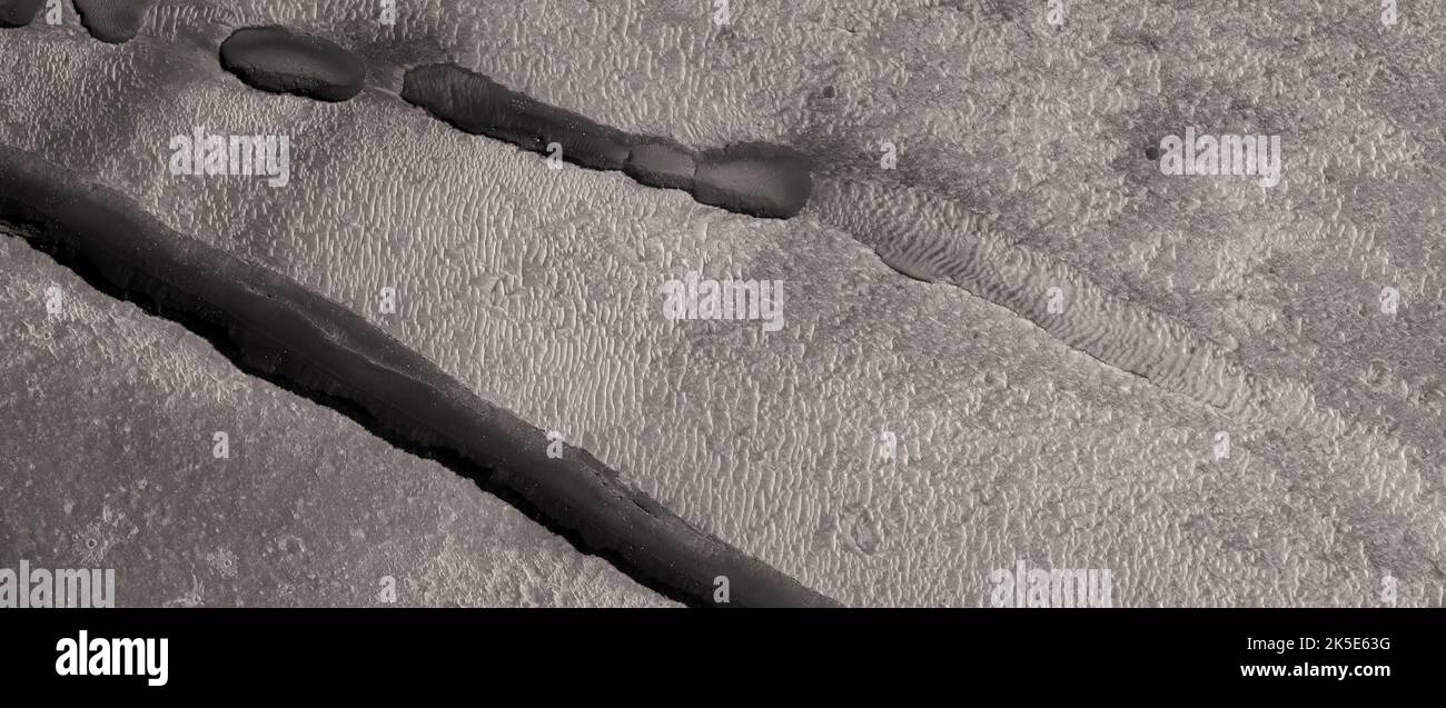 Marsatlandschaft. Dieses HiRISE-Bild zeigt Landformen auf der Oberfläche des Mars. Mehrere Zweige der Cerberus Fossae die Cerberus Fossae sind eine Reihe von halbparallelen Spalten auf dem Mars, die durch Verwerfungen gebildet wurden, die die Kruste in der Cerberus-Region auseinander zogen. Dieses Bild zeigt auch einige ausgerichtete Gruben mit zwei Spalten direkt südlich ihrer Position. Eine einzigartige optimierte Version von NASA-Bildern. Quelle: NASA/JPL/UArizona Stockfoto