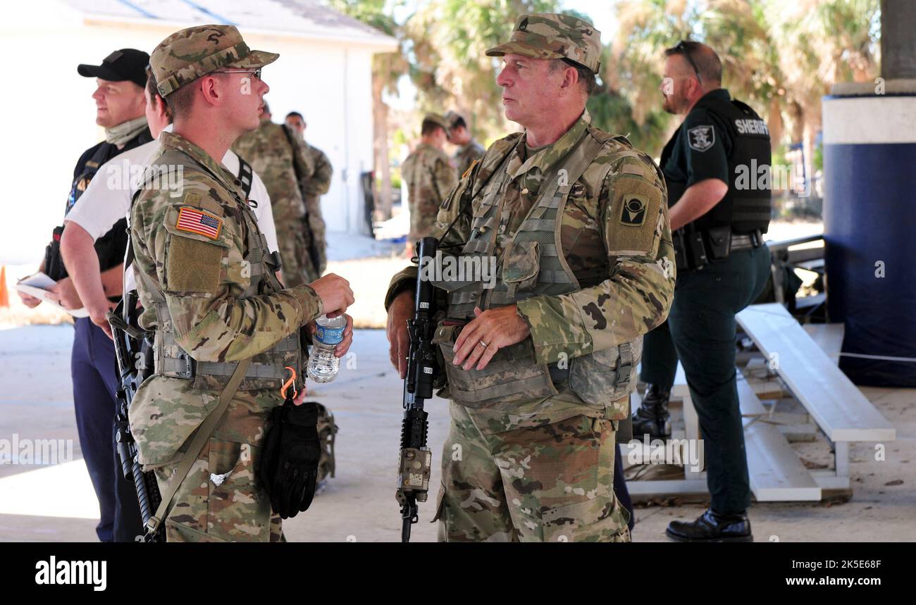 Florida Army National Guard Spc. Daniel Crews und Staff Sgt. James Long wird Bravo Truppe zugewiesen, 1. Squadron, 153. Calvary Regiment Gespräch an einem Einsatzort während der Notfallmaßnahmen des Unruhres Ian in Pine Island Florida 3, Oktober 2022. Die Zerstörung von Pine Island führte dazu, dass Soldaten der Nationalgarde der Florida Army auf dem Hubschrauber der US Army Boeing CH-47 Chinook einflogen, um Operationen einzurichten und die Bewohner auf jede ermögliche Weise zu unterstützen. (Foto der Nationalgarde der Florida Army von Staff Sgt. Cassandra Vieira) Stockfoto