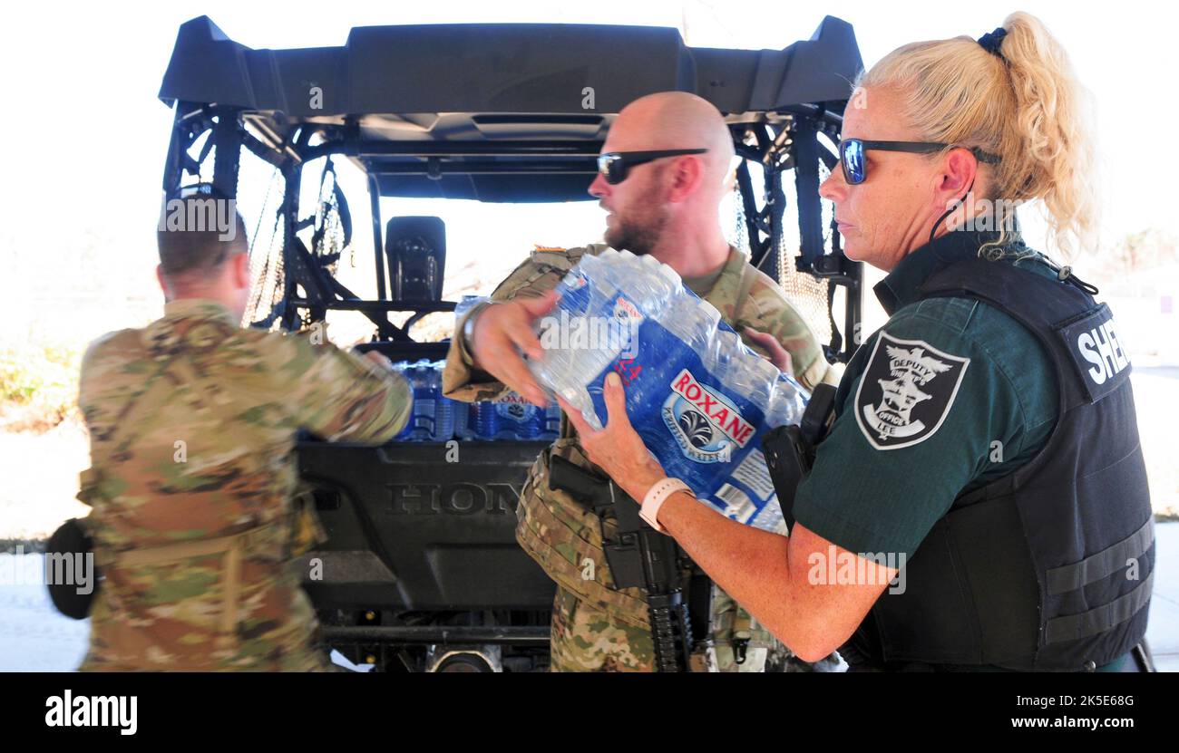 Florida Army National Guard Spc. Caleb Cartwright zugewiesen Charlie Truppe, 1. Squadron, 153. Calvary Regiment entlädt Wasser aus einem Lee County Sheriff stellvertretenden Fahrzeug während der Notfallmaßnahmen Bemühungen von dem Unwetter Ian in Sanibel Island Florida 3, Oktober 2022. Vorräte wie Nahrung und Wasser wurden von der Insel aufgrund der Zerstörung durch den „Ian“ abgeschnitten, die die Bewohner vom ein- und Aussteigen auf dem Landweg einschränkte. (Foto der Nationalgarde der Florida Army von Staff Sgt. Cassandra Vieira) Stockfoto