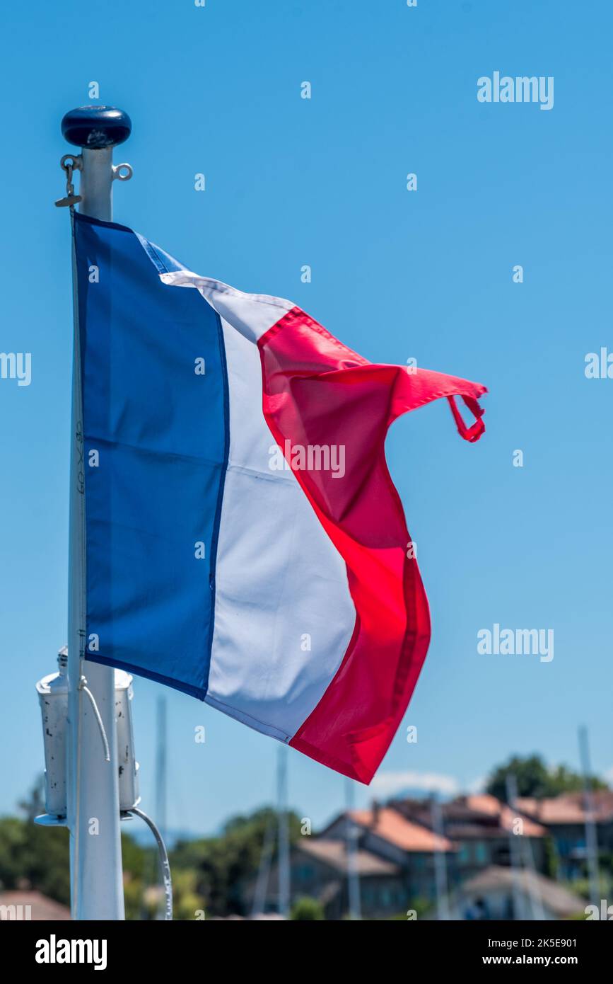 Französische Flagge auf dem Mast über einem blauen Himmel. Stockfoto