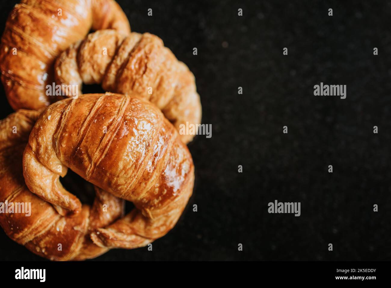 Medialunas, argentinisches süßes Croissant vor schwarzem Hintergrund. Copy Space Stockfoto