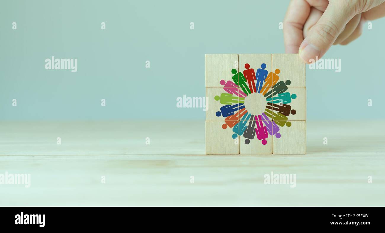 Teambildung und Diversity-Konzept. Arbeiten Sie zusammen, um Ziele zu erreichen und erfolgreiche Geschäfte zu machen. Produktive Mitarbeiterfähigkeiten. Handplatzierte Holzwürfel Stockfoto