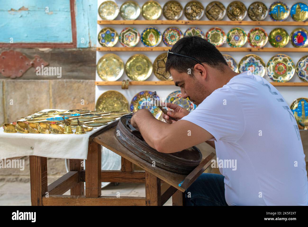 BUCHARA, USBEKISTAN - 10. SEPTEMBER 2022: Meister der künstlerischen Münzprägung Stockfoto