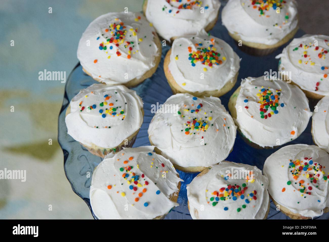 Ein blauer Teller mit dekorierten Cupcakes Stockfoto