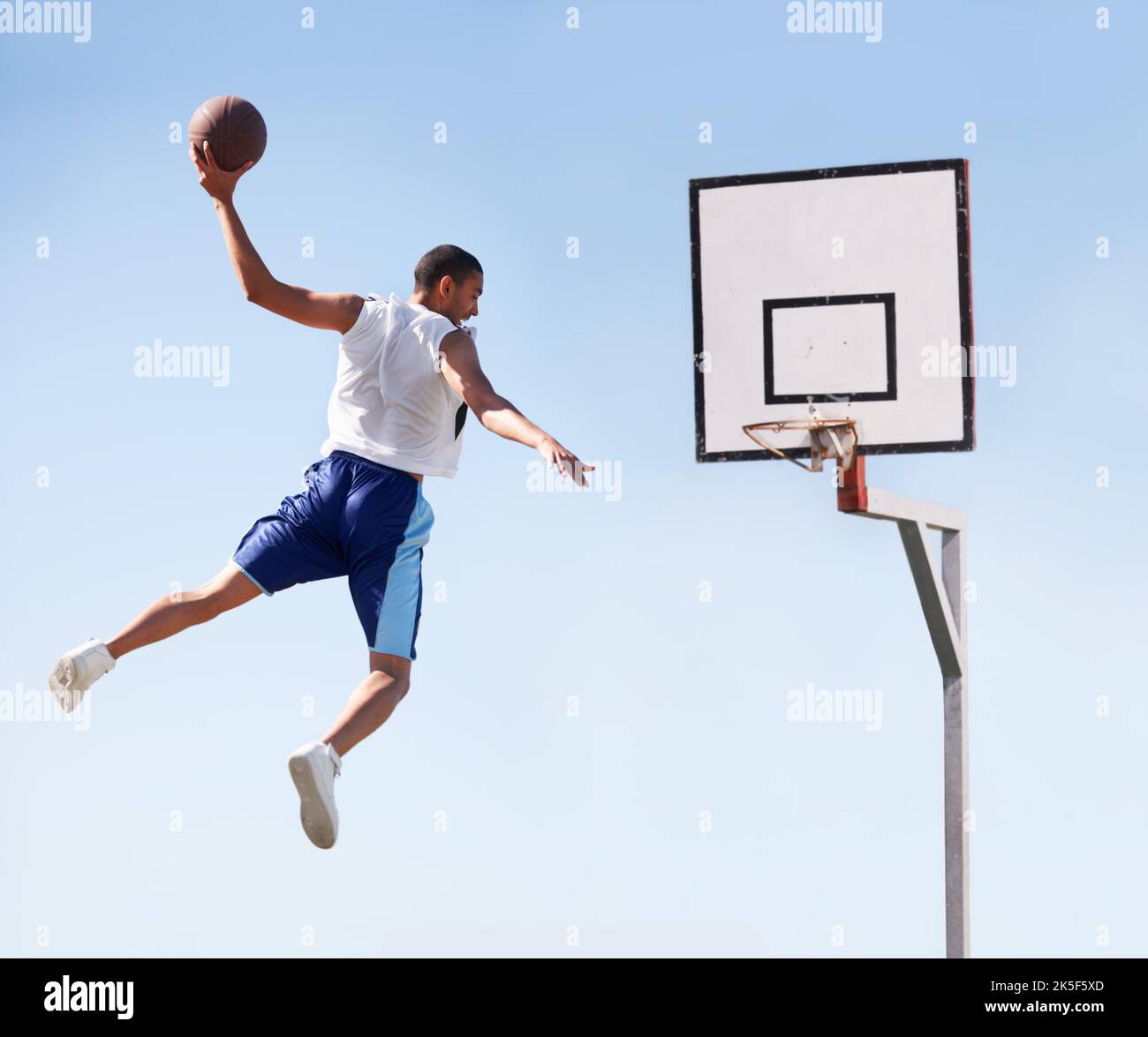 Ich glaube, ich kann fliegen. Ein Sportspieler macht einen fliegenden Slam Dunk. Stockfoto