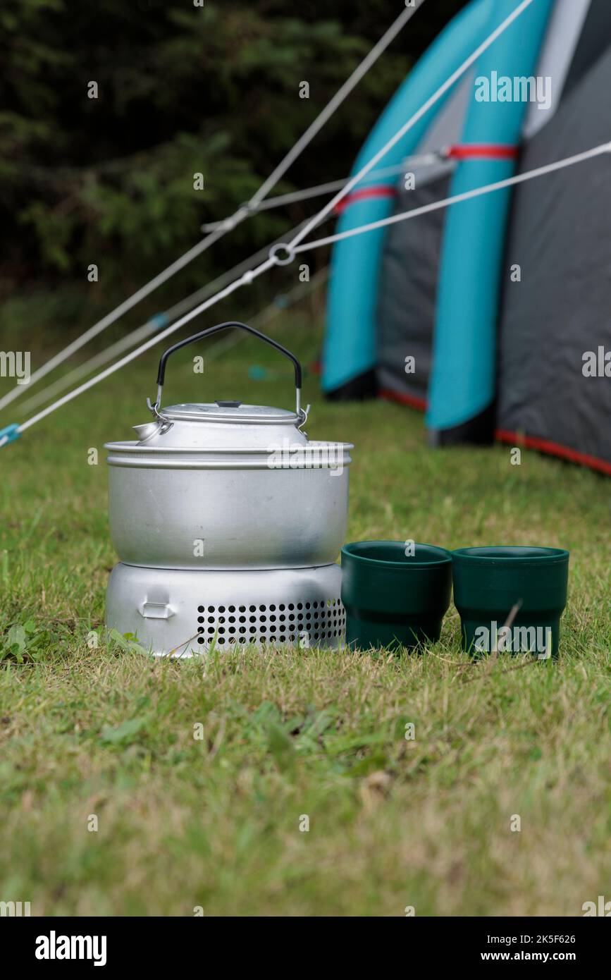 Campingkocher, Tassen und Zelt. Stockfoto