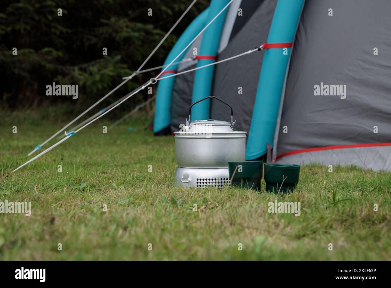 Campingkocher, Tassen und Zelt. Stockfoto