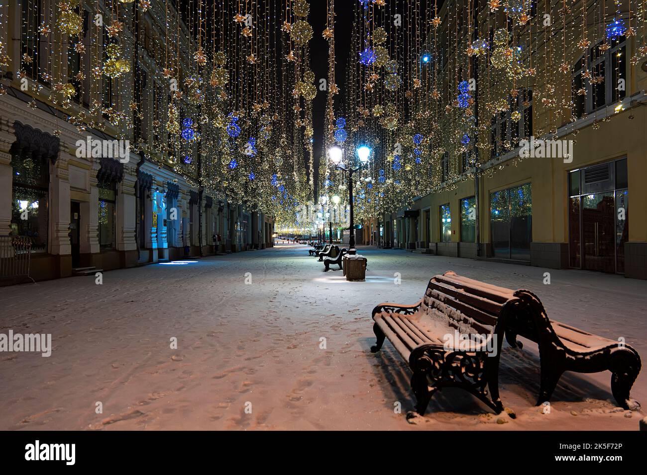 Neujahrsfotos der Stadt, Stadtbeleuchtung. Ein leerer Laden auf einer winterlichen Neujahrsstraße, geschmückt mit Girlanden und Laternen ohne Pfirsich Stockfoto