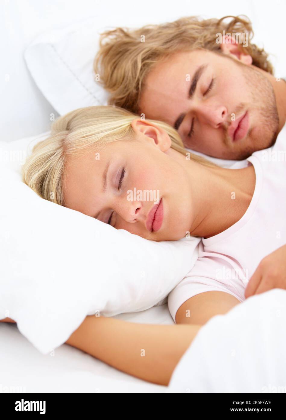 Snooze-Modus. Ein junges Paar schläft fest im Bett zusammen. Stockfoto